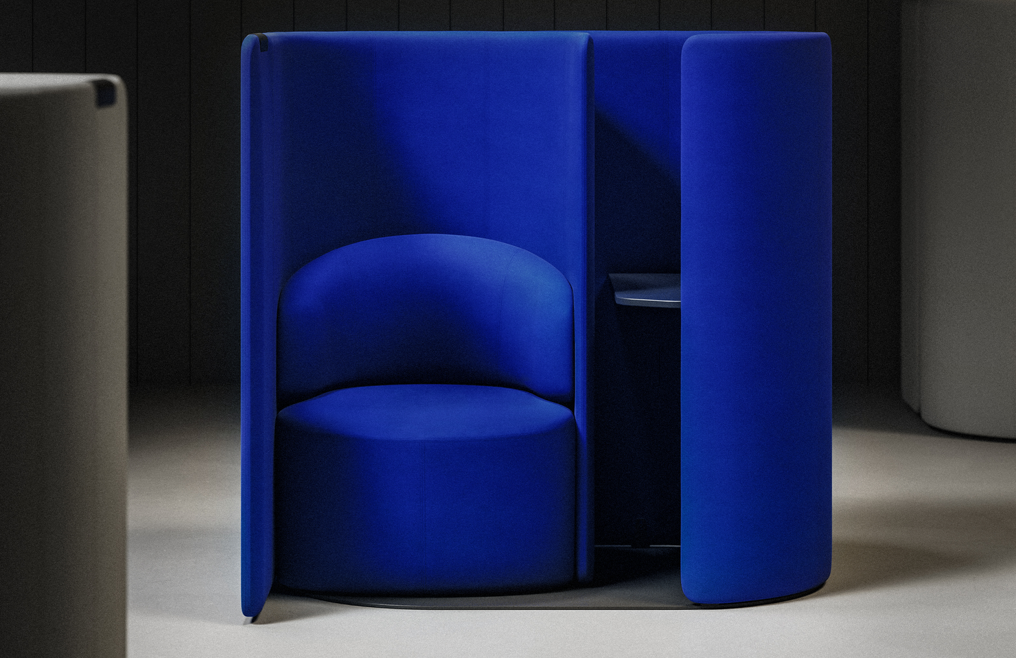 Blue fabric work pod with a gray floor and dark background