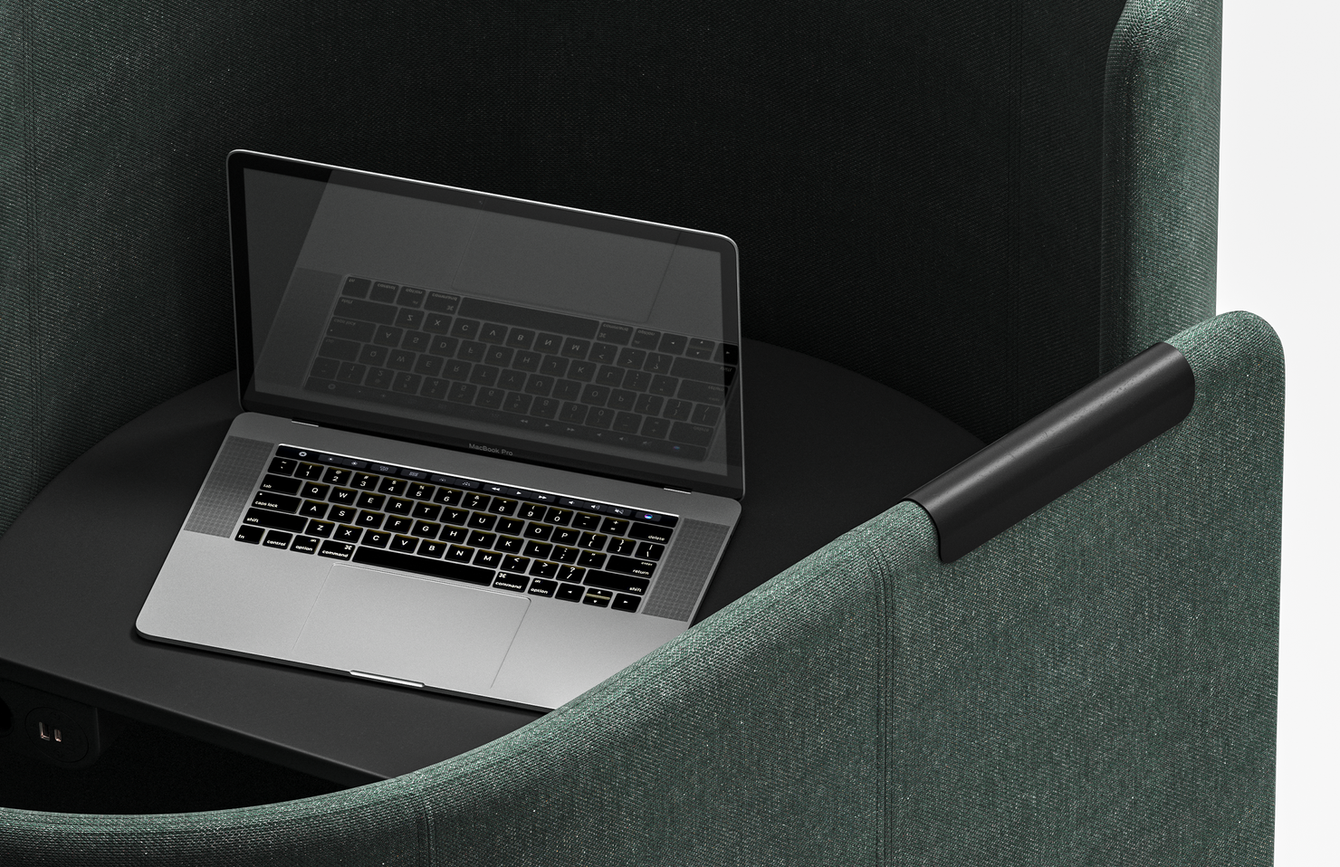 Laptop on a round table inside a green work pod. 