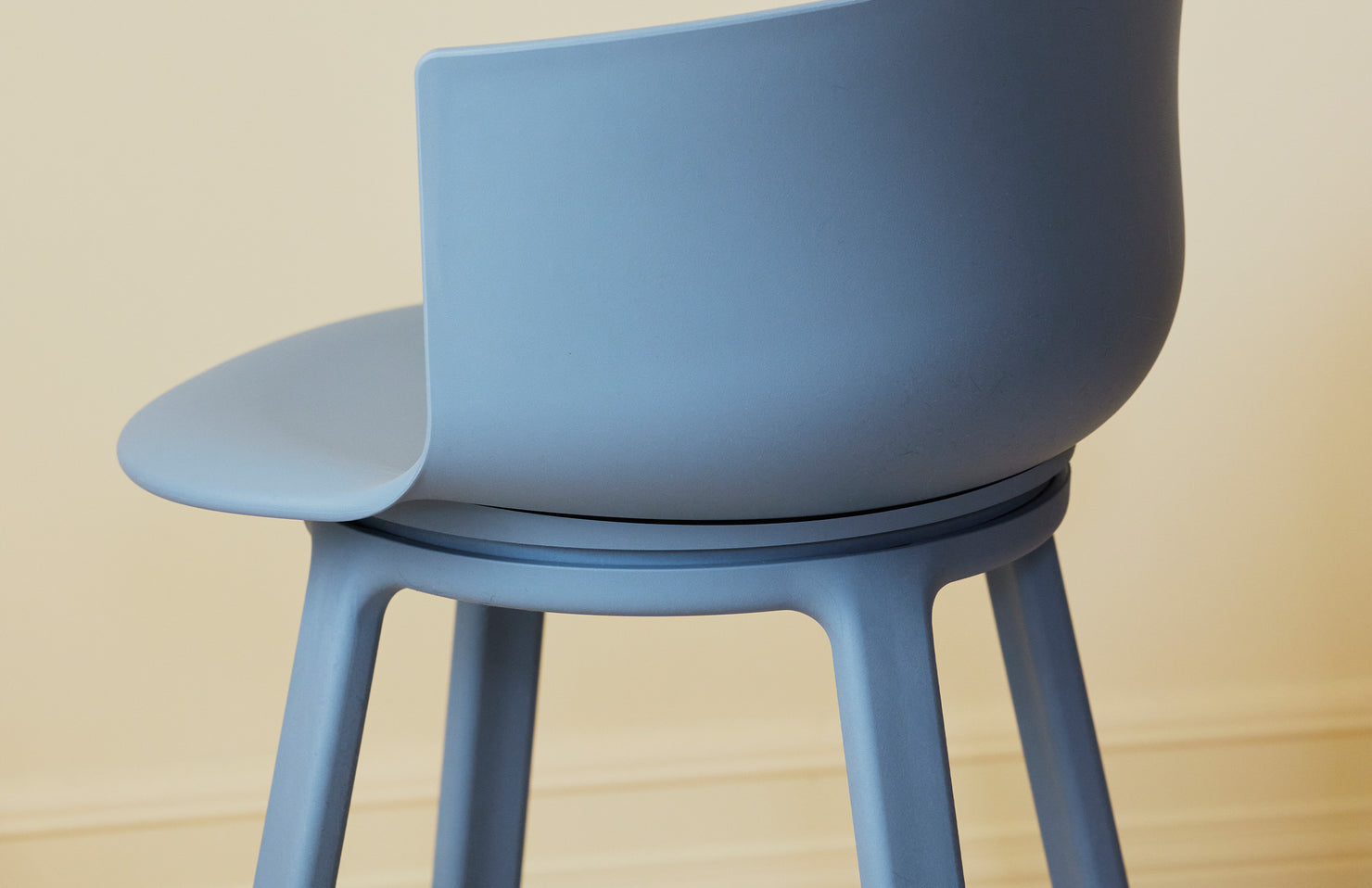 Blue turn chair on a wooden floor with a neutral background